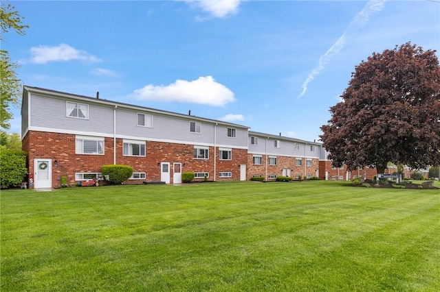 275 Owens Rd Unit 115, Sweden, NY 14420 - rear view of house featuring a yard and brick siding