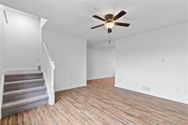 275 Owens Rd Unit 115, Sweden, NY 14420 - unfurnished living room with wood finished floors, ceiling fan, stairs, and baseboards