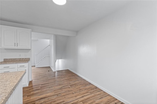 275 Owens Rd Unit 115, Sweden, NY 14420 - unfurnished dining area featuring baseboards, wood finished floors, and stairway