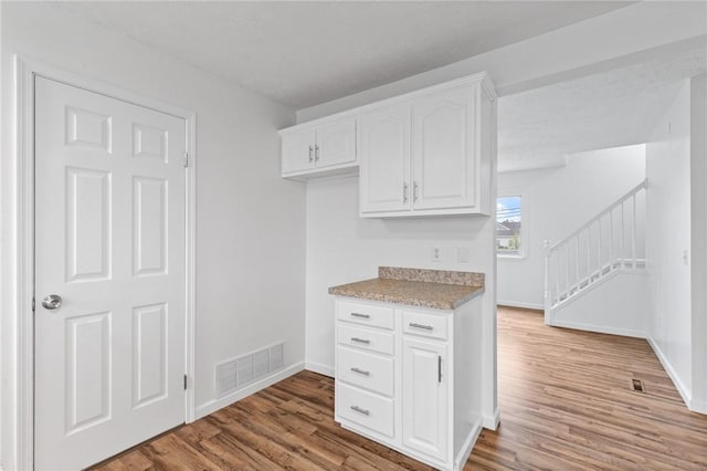 275 Owens Rd Unit 115, Sweden, NY 14420 - kitchen featuring light wood-style flooring, baseboards, and white cabinetry
