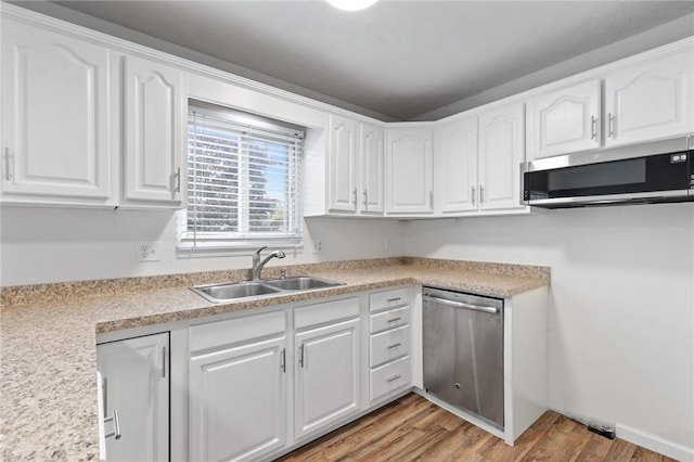 275 Owens Rd Unit 115, Sweden, NY 14420 - kitchen with stainless steel appliances, a sink, white cabinets, light wood-style floors, and light countertops