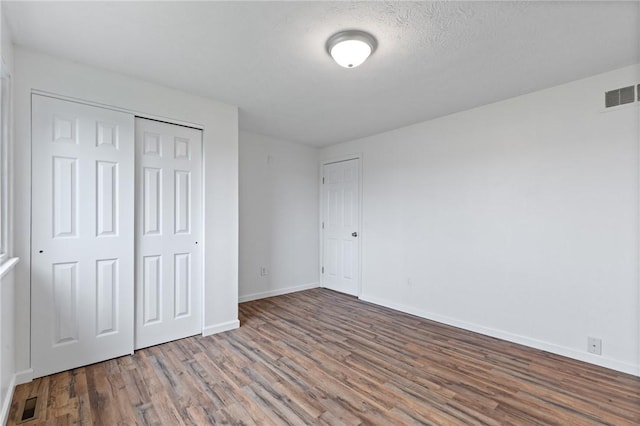 275 Owens Rd Unit 115, Sweden, NY 14420 - unfurnished bedroom featuring wood finished floors, baseboards, and a closet