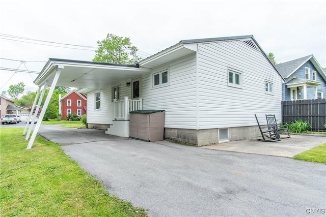 1039 Holcomb St, Watertown-City, NY 13601 - view of side of property featuring a carport and asphalt driveway