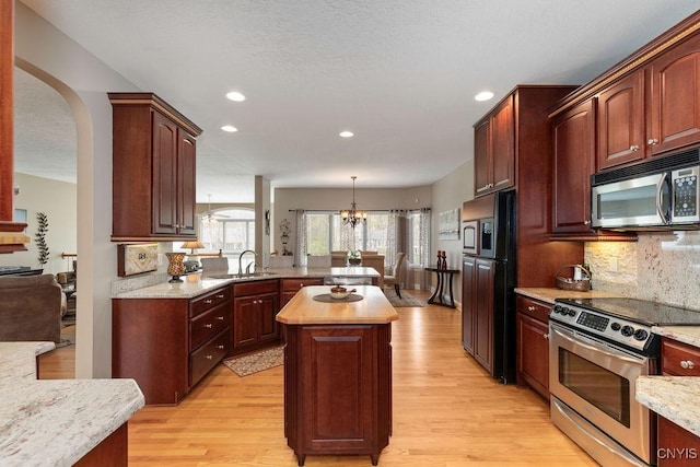 1968 Penfold Way, Lysander, NY 13027 - kitchen featuring appliances with stainless steel finishes, a chandelier, light wood finished floors, a sink, and tasteful backsplash