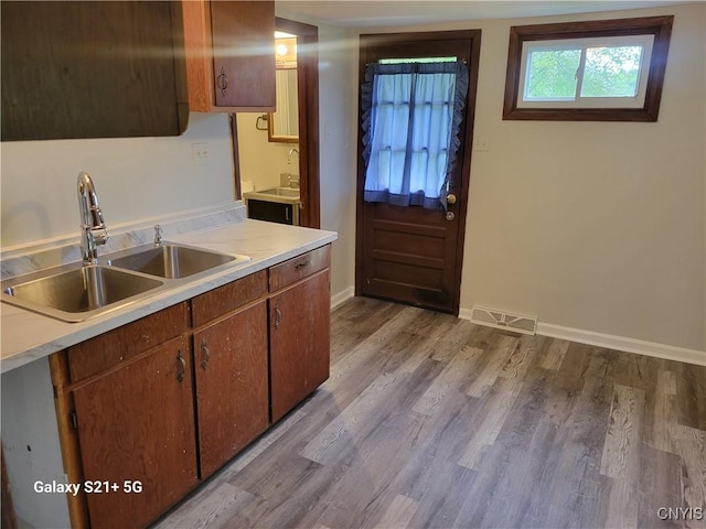 8723 E Mud Lake Rd, Lysander, NY 13027 - kitchen featuring a sink, wood finished floors, light countertops, and baseboards