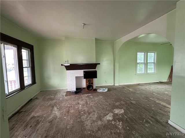 23 Cayuga St, Buffalo, NY 14211 - unfurnished living room featuring arched walkways, wood finished floors, baseboards, and a fireplace