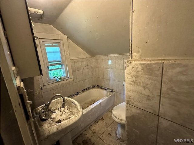 23 Cayuga St, Buffalo, NY 14211 - full bathroom featuring vaulted ceiling, a bath, tile walls, toilet, and tile patterned flooring