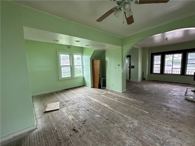 23 Cayuga St, Buffalo, NY 14211 - unfurnished living room featuring arched walkways, plenty of natural light, a ceiling fan, and baseboards