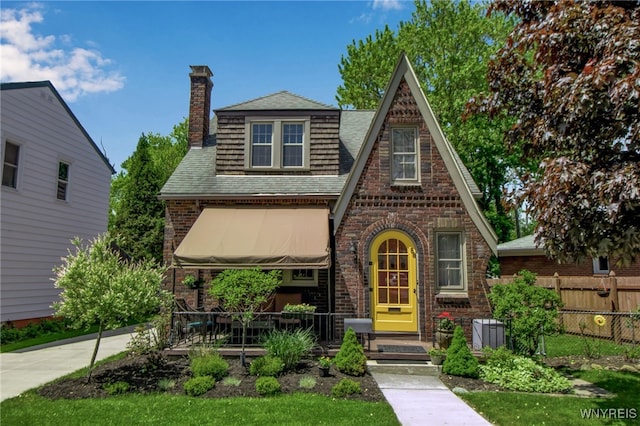 88 Garland Dr, Amherst, NY 14226 - tudor home featuring a chimney, brick siding, and roof with shingles