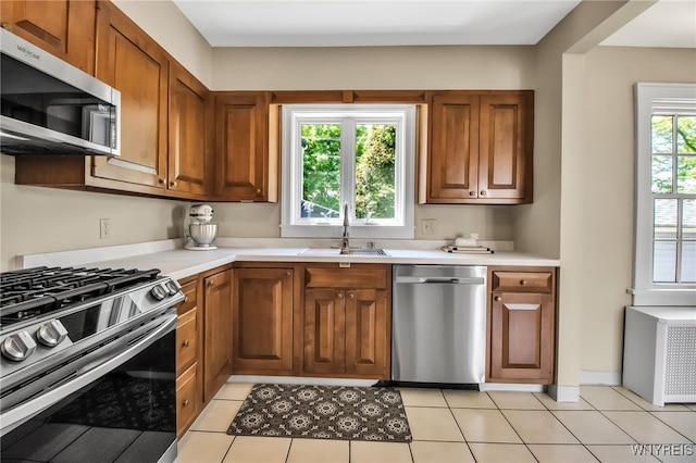 88 Garland Dr, Amherst, NY 14226 - kitchen featuring appliances with stainless steel finishes, a sink, light countertops, and brown cabinets