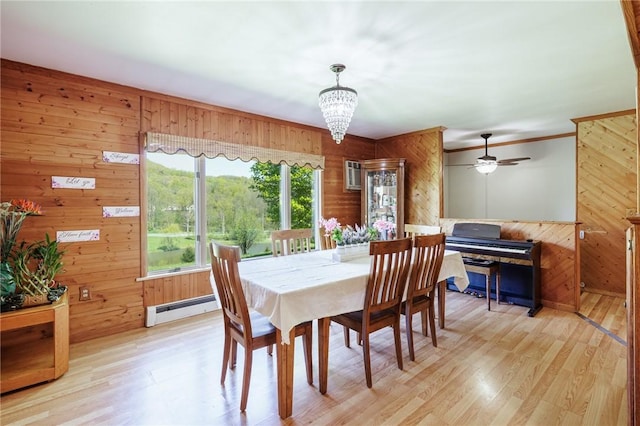 7425 Eelpot Rd, Naples, NY 14512 - dining area featuring baseboard heating, wood walls, light wood-type flooring, a chandelier, and ornamental molding