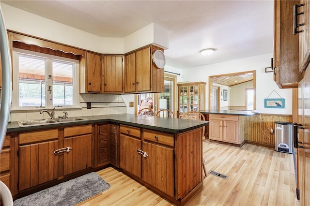 7425 Eelpot Rd, Naples, NY 14512 - kitchen with a peninsula, a sink, light wood-style floors, dark countertops, and wainscoting