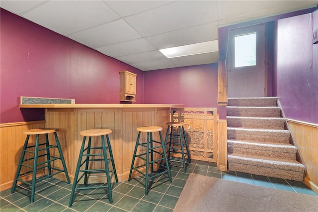 101 Winchell Rd, Owego, NY 13827 - indoor dry bar with wainscoting, wood walls, stairs, tile patterned floors, and a paneled ceiling