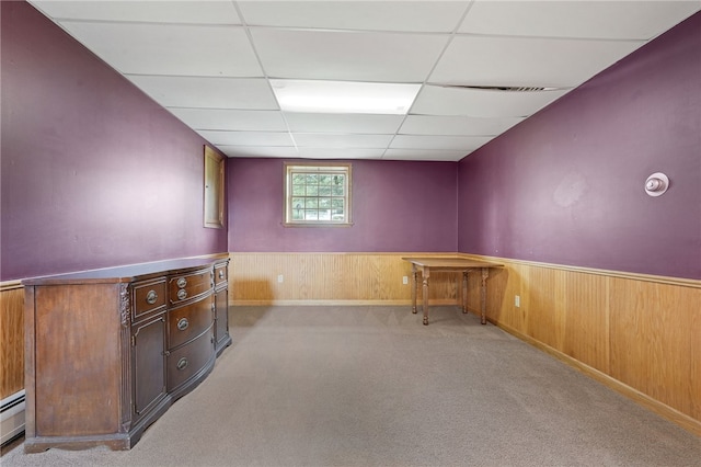 101 Winchell Rd, Owego, NY 13827 - basement featuring a paneled ceiling, baseboard heating, carpet floors, wooden walls, and wainscoting