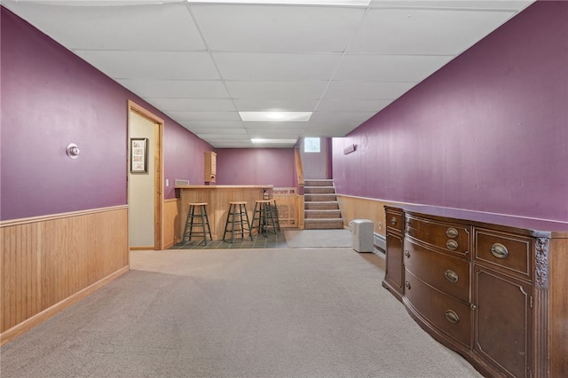 101 Winchell Rd, Owego, NY 13827 - below grade area featuring a bar, a drop ceiling, carpet flooring, wooden walls, and wainscoting