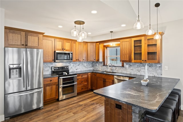 8419 Old Lake Rd, Lodi, NY 14860 - kitchen with appliances with stainless steel finishes, a sink, a peninsula, brown cabinets, and recessed lighting