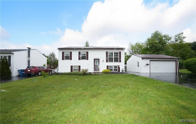 704 Beach Rd, Evans, NY 14006 - raised ranch featuring a garage, a front yard, and an outbuilding