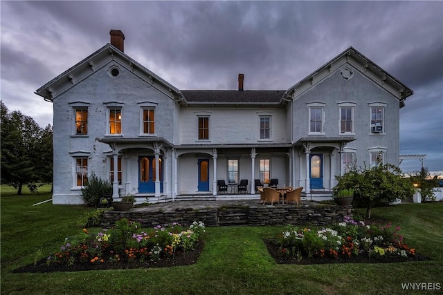 9940 Middle Rd, Pulteney, NY 14840 - italianate-style house featuring a porch, a front yard, a chimney, and stucco siding