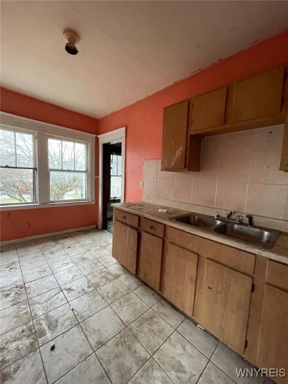 115 Stratford Rd, Buffalo, NY 14216 - kitchen with a sink, decorative backsplash, light countertops, light tile patterned floors, and brown cabinetry