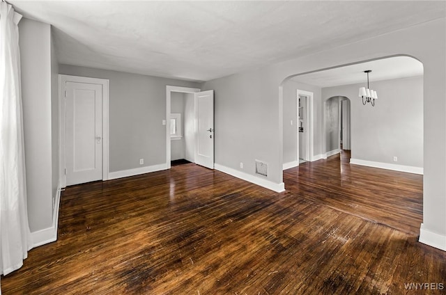374 Victoria Blvd, Tonawanda-Town, NY 14217 - unfurnished room featuring arched walkways, dark wood finished floors, baseboards, and a chandelier