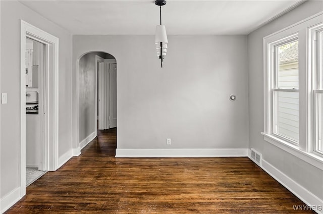 374 Victoria Blvd, Tonawanda-Town, NY 14217 - unfurnished dining area with arched walkways, dark wood-type flooring, and baseboards