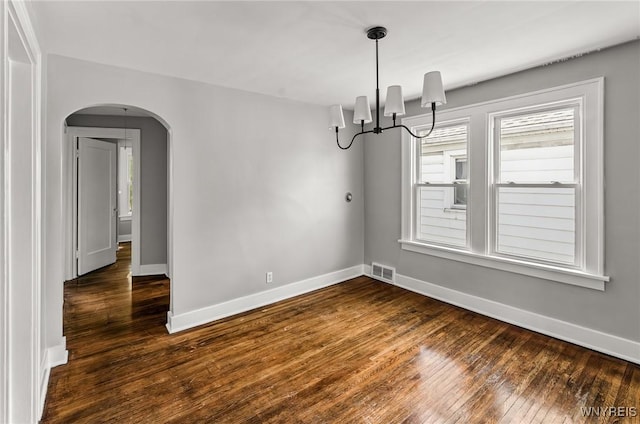 374 Victoria Blvd, Tonawanda-Town, NY 14217 - empty room featuring arched walkways, dark wood finished floors, baseboards, and a chandelier