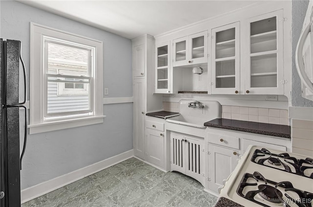 374 Victoria Blvd, Tonawanda-Town, NY 14217 - kitchen featuring tasteful backsplash, white cabinetry, freestanding refrigerator, and glass insert cabinets
