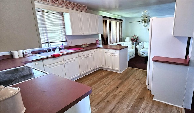 11 Donna Marie Cir, Gates, NY 14606 - kitchen with a sink, wood finished floors, white cabinets, a peninsula, and dark countertops