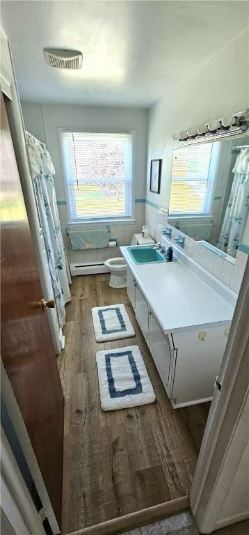 11 Donna Marie Cir, Gates, NY 14606 - bathroom with wood finished floors, vanity, toilet, a wainscoted wall, and baseboard heating