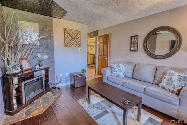 26 Pine Tree Village Rd Unit 26, Ellicottville, NY 14731 - living area with wood finished floors, a fireplace, a textured ceiling, and baseboards