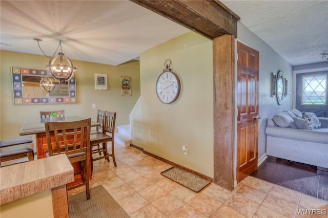 26 Pine Tree Village Rd Unit 26, Ellicottville, NY 14731 - dining area featuring a chandelier, a textured ceiling, and baseboards