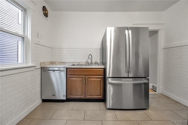 75 N Park Ave, Buffalo, NY 14216 - kitchen featuring stainless steel appliances, a sink, tile walls, light countertops, and light tile patterned floors