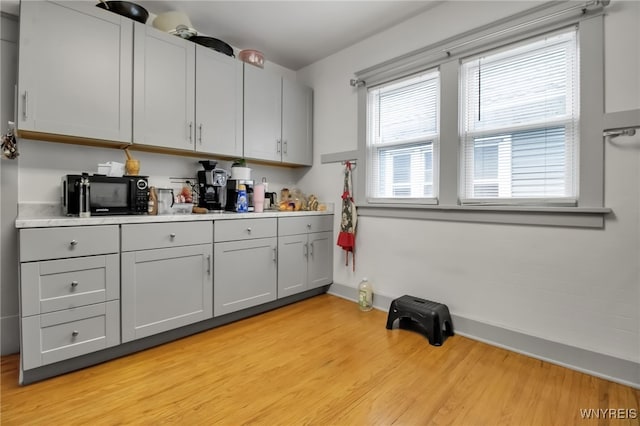 75 N Park Ave, Buffalo, NY 14216 - kitchen with black microwave, gray cabinets, light wood-style flooring, baseboards, and light countertops