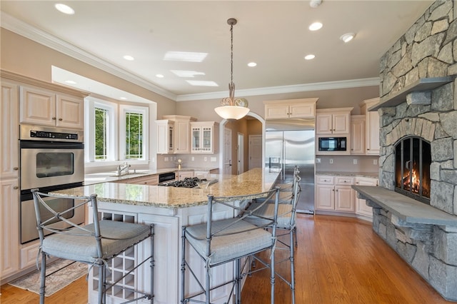 436 Steuben St, Reading, NY 14891 - kitchen with built in appliances, a center island, a breakfast bar area, a fireplace, and crown molding