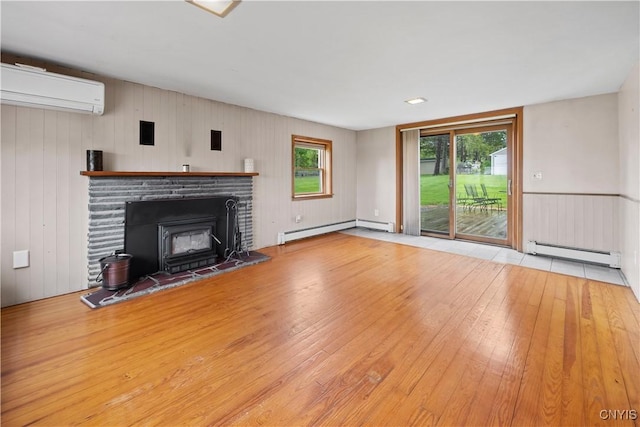 3583 W Seneca Tpke, Onondaga, NY 13215 - unfurnished living room featuring a wall mounted AC, baseboard heating, hardwood / wood-style flooring, a baseboard heating unit, and plenty of natural light