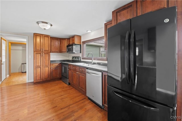 3583 W Seneca Tpke, Onondaga, NY 13215 - kitchen featuring appliances with stainless steel finishes, a sink, light wood-style floors, brown cabinetry, and dark countertops