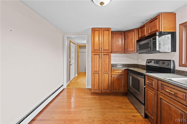 3583 W Seneca Tpke, Onondaga, NY 13215 - kitchen with stainless steel appliances, baseboard heating, dark countertops, light wood finished floors, and brown cabinets