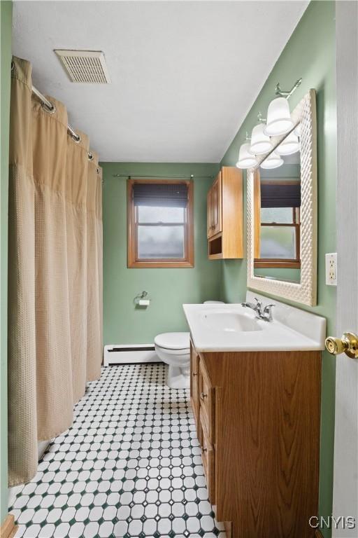 3583 W Seneca Tpke, Onondaga, NY 13215 - bathroom featuring vanity, toilet, a baseboard heating unit, and curtained shower