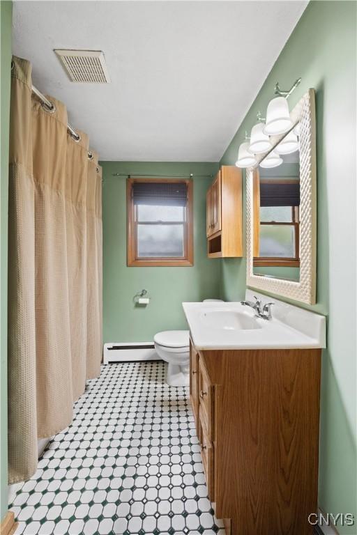 3583 W Seneca Tpke, Onondaga, NY 13215 - full bathroom featuring vanity, toilet, baseboard heating, and a shower with curtain