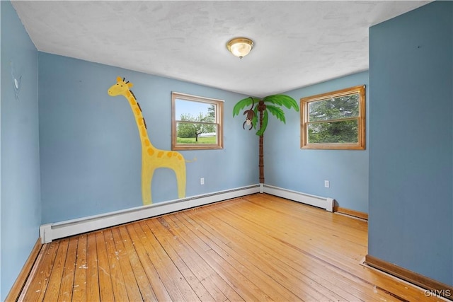 3583 W Seneca Tpke, Onondaga, NY 13215 - spare room with hardwood / wood-style flooring, healthy amount of natural light, a baseboard heating unit, and baseboards