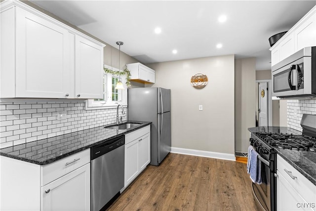 915 W Thomas St, Rome-Inside, NY 13440 - kitchen featuring appliances with stainless steel finishes, a sink, baseboards, dark stone countertops, and decorative backsplash