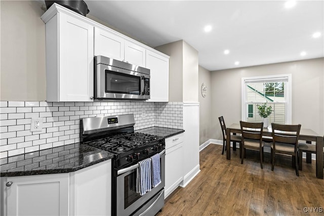 915 W Thomas St, Rome-Inside, NY 13440 - kitchen with appliances with stainless steel finishes, decorative backsplash, dark wood-style floors, dark stone counters, and white cabinets