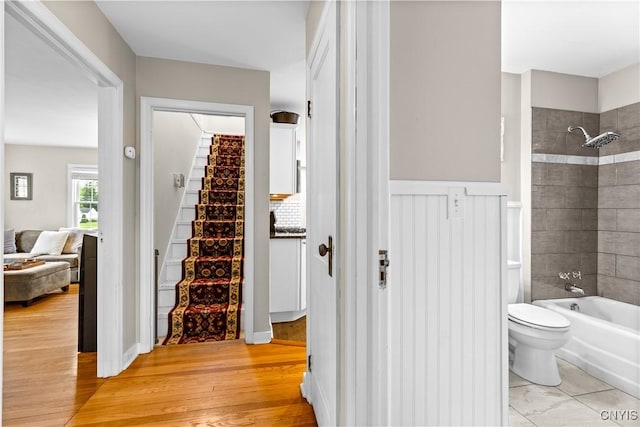 915 W Thomas St, Rome-Inside, NY 13440 - full bath with toilet, shower / washtub combination, wood finished floors, and a wainscoted wall