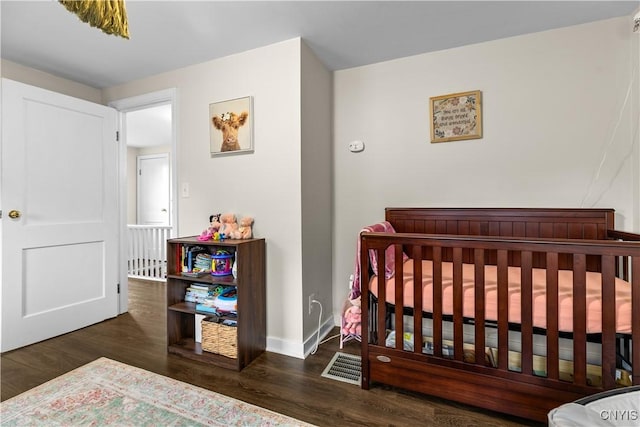 915 W Thomas St, Rome-Inside, NY 13440 - bedroom with wood finished floors, baseboards, and a crib