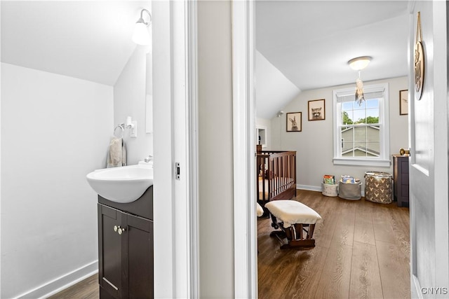 915 W Thomas St, Rome-Inside, NY 13440 - bathroom with lofted ceiling, wood finished floors, vanity, and baseboards