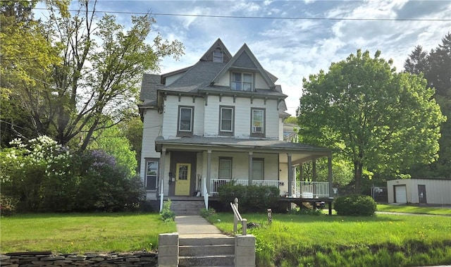 104 Main St, Stamford, NY 12167 - victorian-style house featuring a porch, a front lawn, roof with shingles, and an outbuilding
