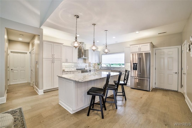 5692 Ferncrest Ct Unit B, Clarence, NY 14032 - kitchen with stainless steel appliances, wall chimney range hood, light wood-style flooring, decorative backsplash, and a center island