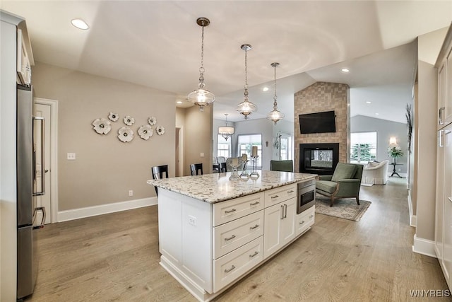 5692 Ferncrest Ct Unit B, Clarence, NY 14032 - kitchen with freestanding refrigerator, lofted ceiling, baseboards, light wood finished floors, and plenty of natural light