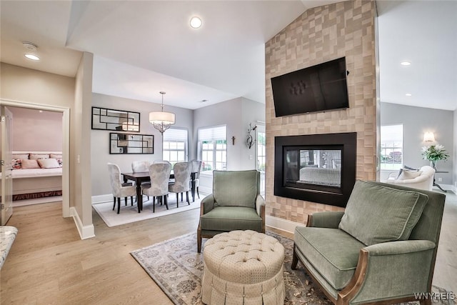 5692 Ferncrest Ct Unit B, Clarence, NY 14032 - living area featuring vaulted ceiling, baseboards, a multi sided fireplace, light wood-type flooring, and recessed lighting