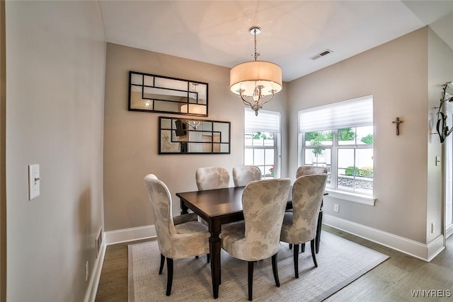 5692 Ferncrest Ct Unit B, Clarence, NY 14032 - dining area with wood finished floors, baseboards, and a chandelier